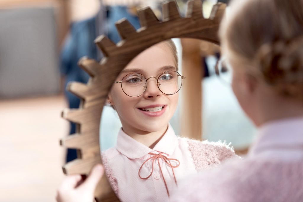 Child looking in a mirror developing a positive sense of self