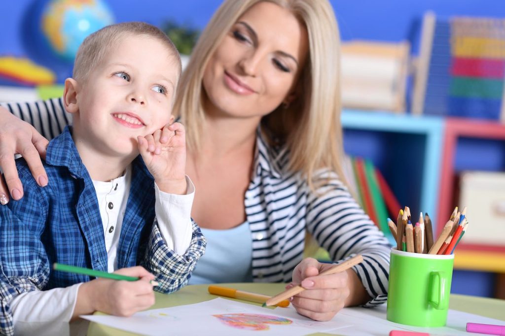 Child reflecting on a drawing while being supported with kindness